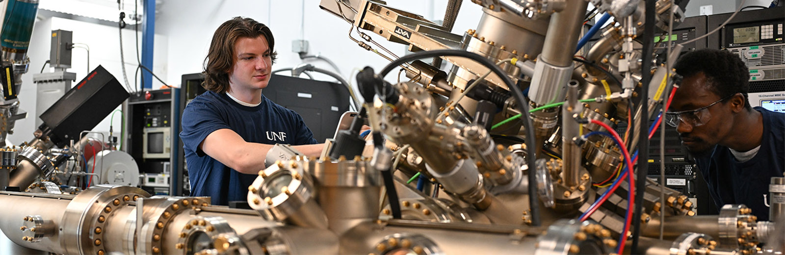 Students working on physics and engineering equipment in a lab