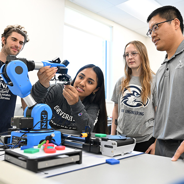 students and professor working on with machine to 3d print materials