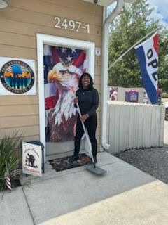 Owner of business in front of her office holding mop