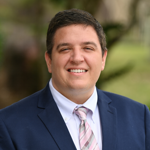 Headshot of Nick Roshkind, he's smiling and wearing a suit.
