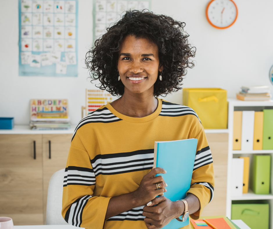 A teacher smiles in her classroom.