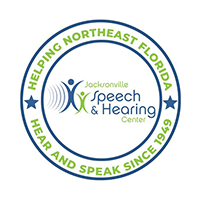 Jacksonville Speech & Hearing Center logo in a circular badge with green and blue text reading “Helping Northeast Florida” and “Hear and Speak Since 1929.”