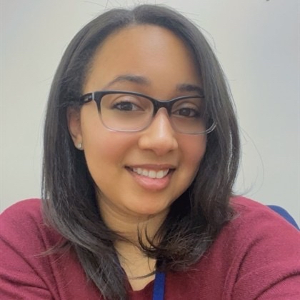 Headshot of Simone Hester wearing glasses and a maroon t-shirt