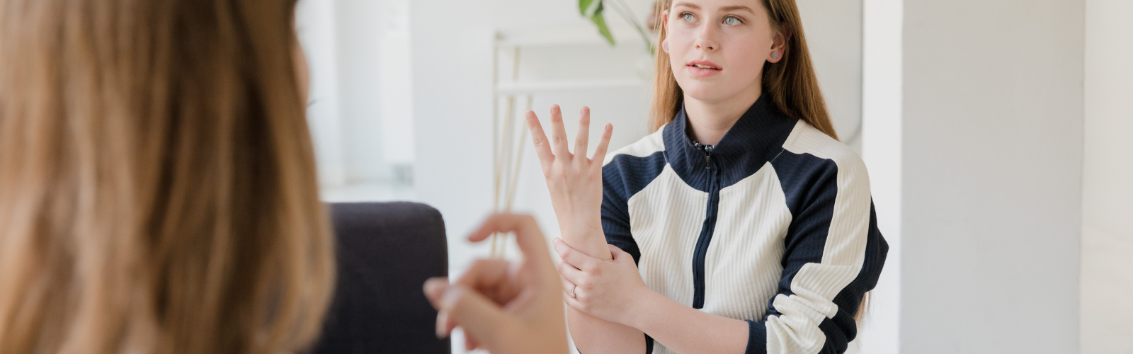 Two women communicate using American Sign Language.
