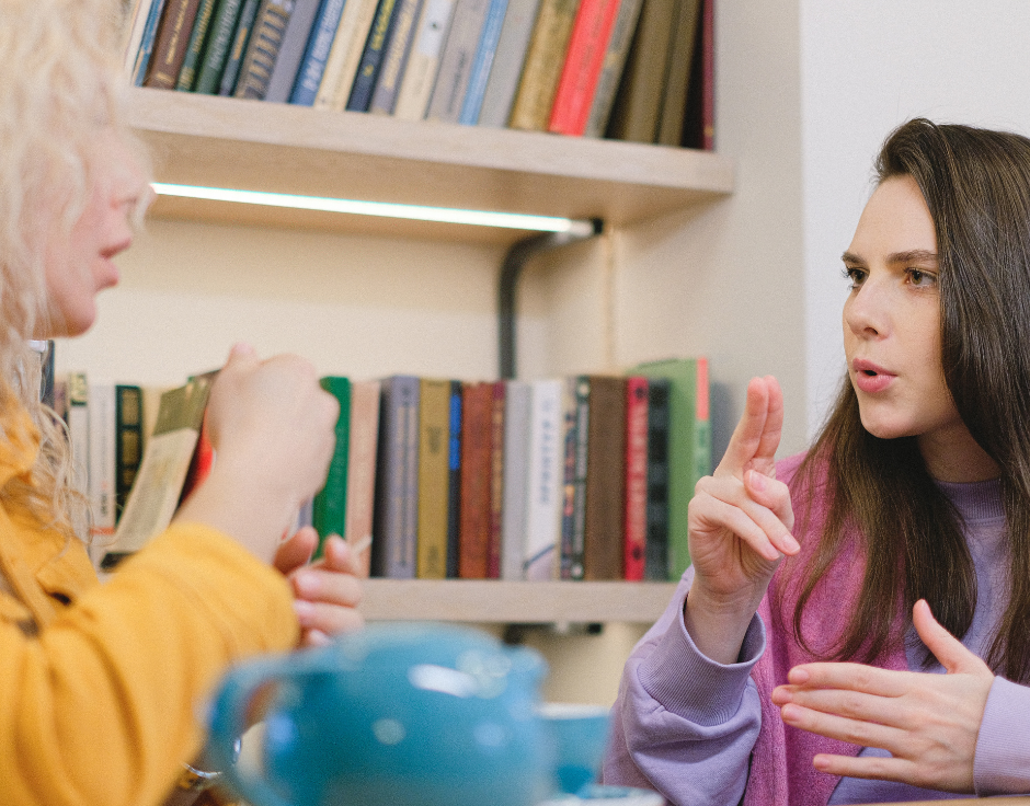 Two women communicate using American Sign Language.