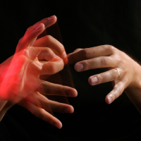 Two hands signing in ASL with motion blur and red lighting.