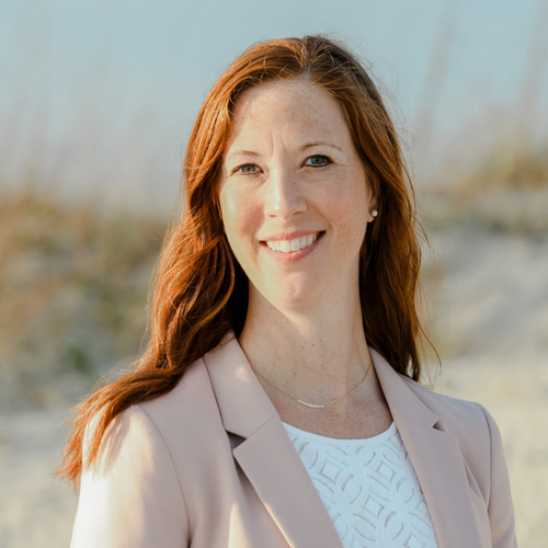 Dr. Jennifer Kilpatrick smiles while standing outside at the beach.