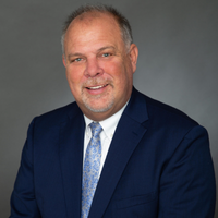 Headshot of Christopher Bernier in a navy suit and blue tie