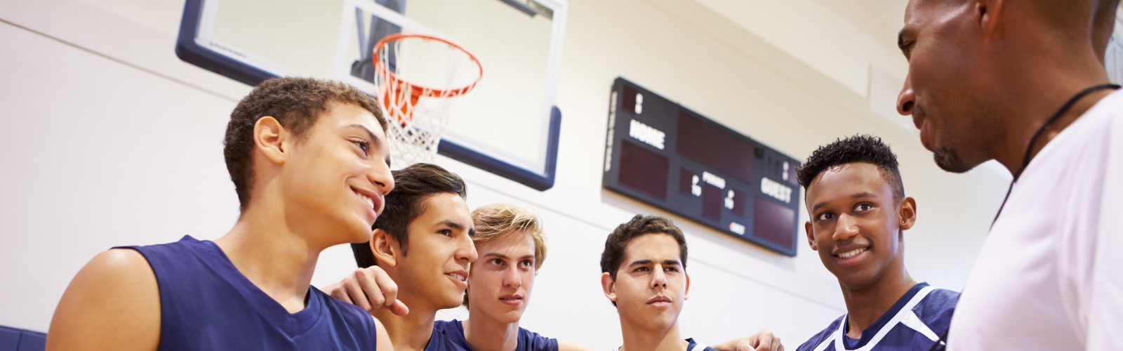 Basketball coach talking with his high school players on the court