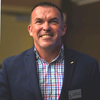 Headshot of Matt Ohlson in suit jacket and plaid button down