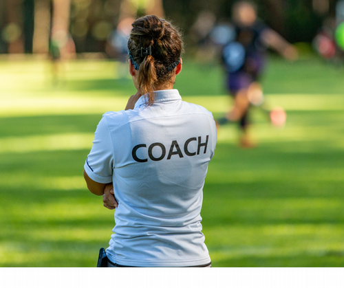 Female Soccer Coach on field with her back to the camera