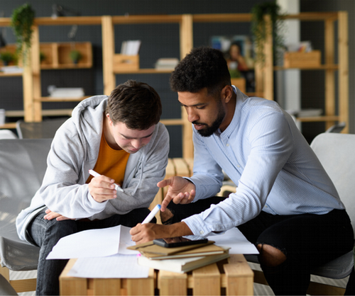 A young professional assisting a young man with paperwork