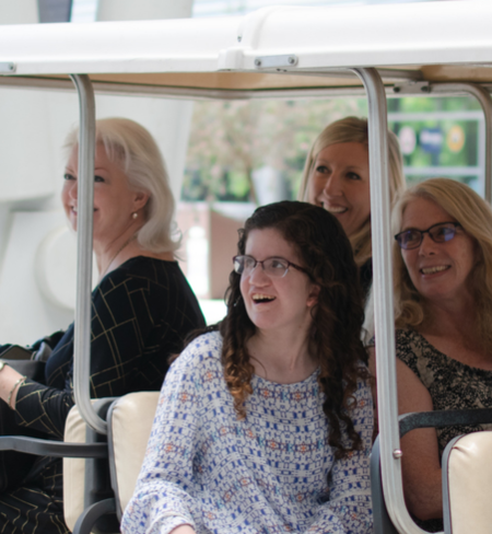 UNF OCT student and supportive adults smiling on golf cart