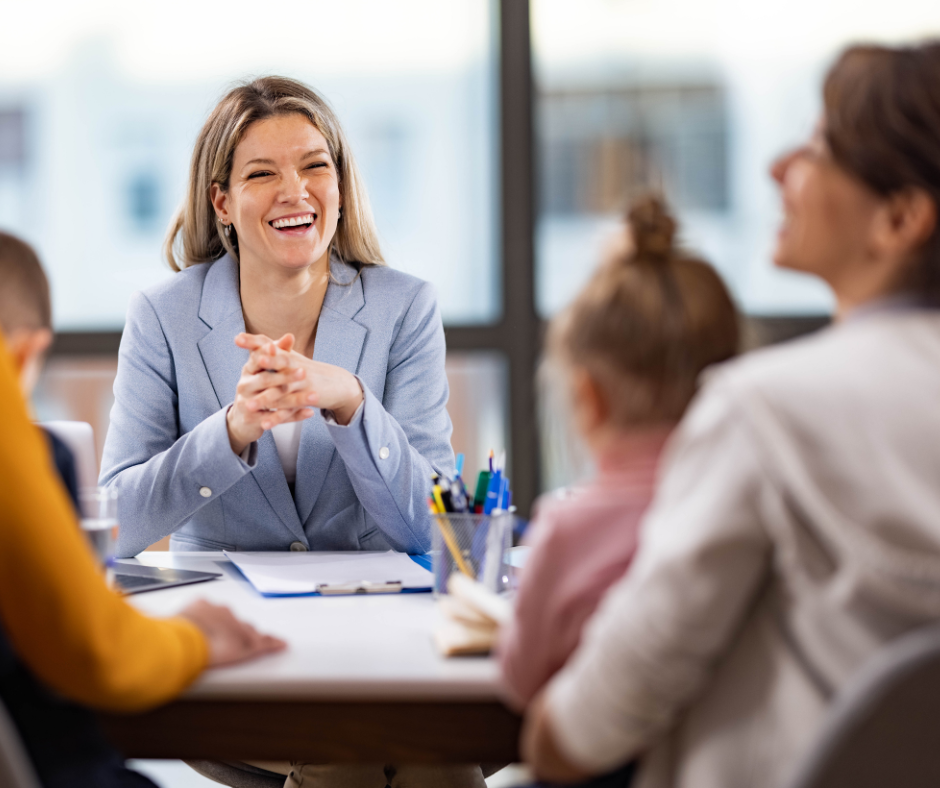 A principal talks with parents and students in her office. 