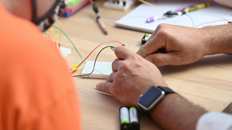 close up of hands and colorful wires for STEM activity 