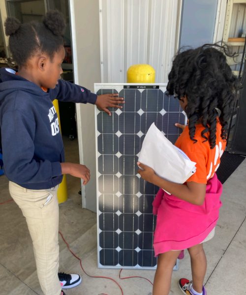 Two Tiger students looking at solar panels in the lab