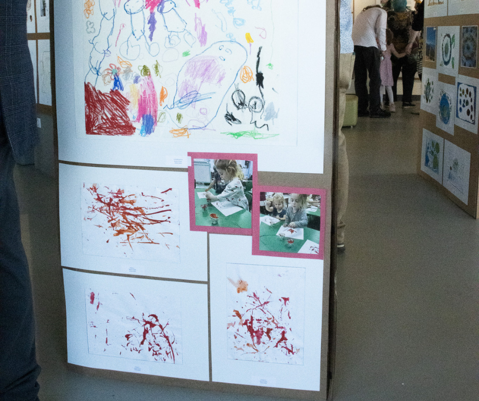 Display of children's art work and photos of them creating it. 