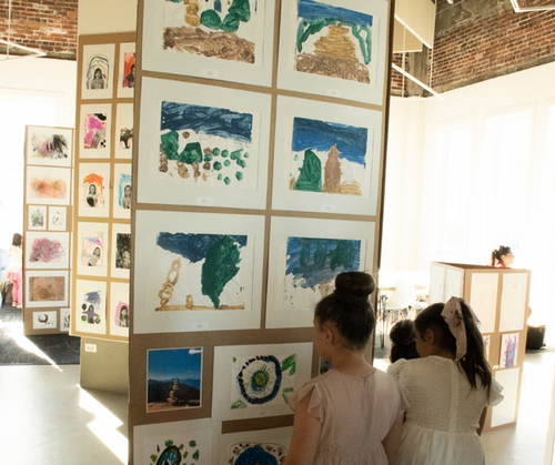 Children looking at UNF preschooler's art on gallery wall at MOCA exhibit