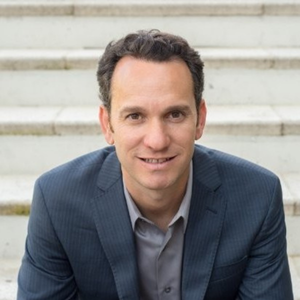 Brian DAmato in navy suit on staircase