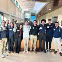 Sport Data Analytics club members smiling together at a conference 