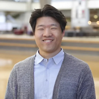 Headshot of Taeho Kim in cardigan and button down