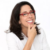 Headshot of Donna Orender smiling with red glasses and white shirt