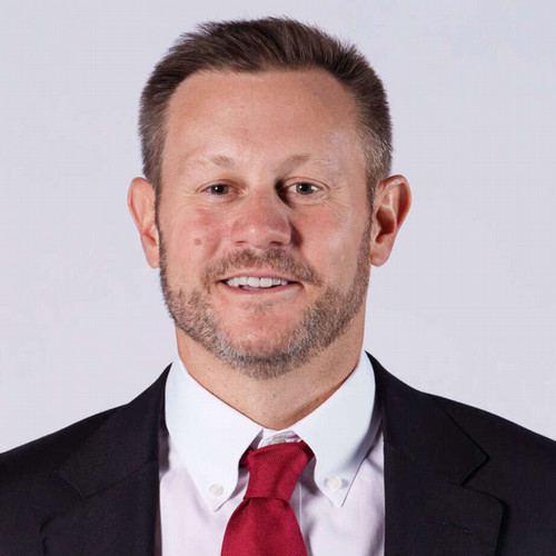 Headshot of Ryan Silverfield smiling in suit and red tie