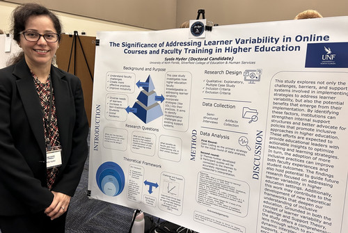 A woman stands by a poster about learner variability in online courses.