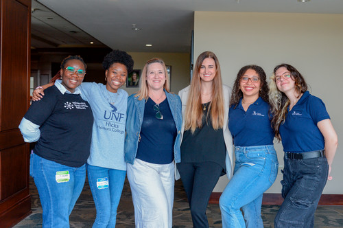 Students and Faculty pose together smiling.