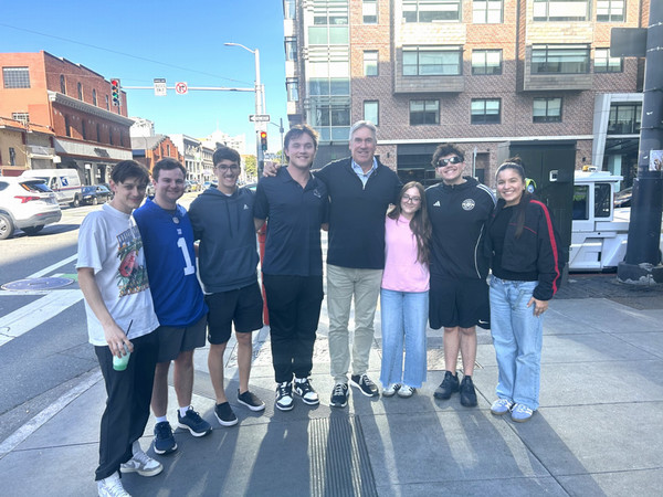 Group photo of sport management students outside on street smiling