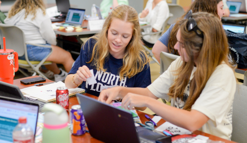 Two UNF students and teacher candidates actively participating in a classroom activity