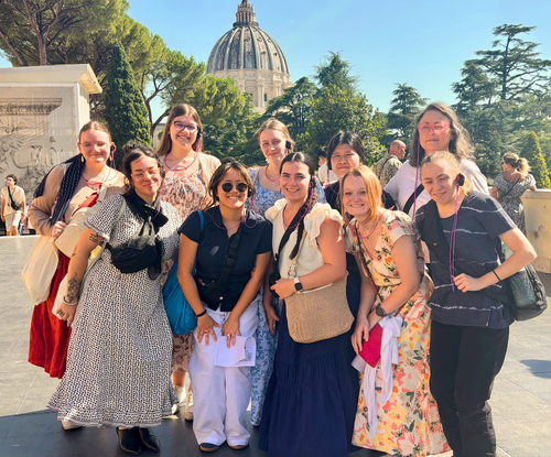 UNF students and faculty smiling together on the vibrant streets of Rome