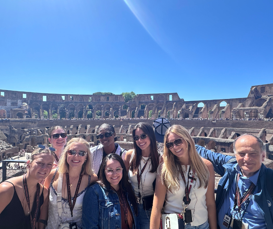 A group of students stand in the Colosseum.