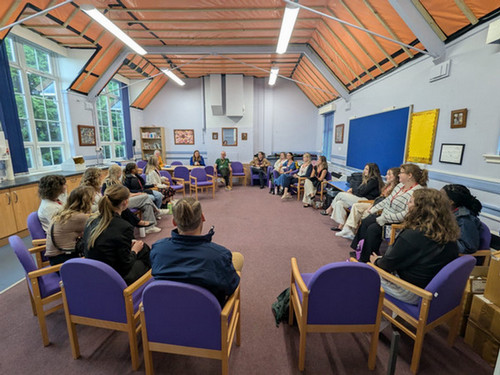 UNF students and faculty sitting in a meeting space in Italy