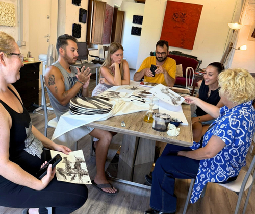 Study abroad students with Rossella looking at art at a table