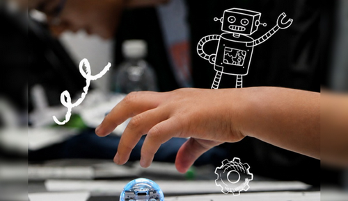Close-up of a hand reaching toward a small blue robot toy on a table.