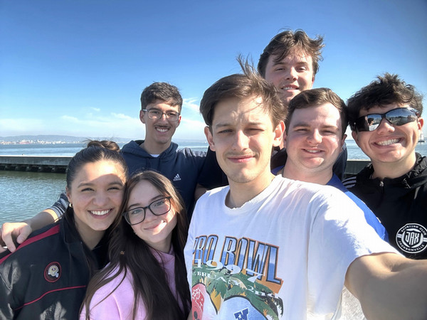 Group of Sport Management students take selfie near water