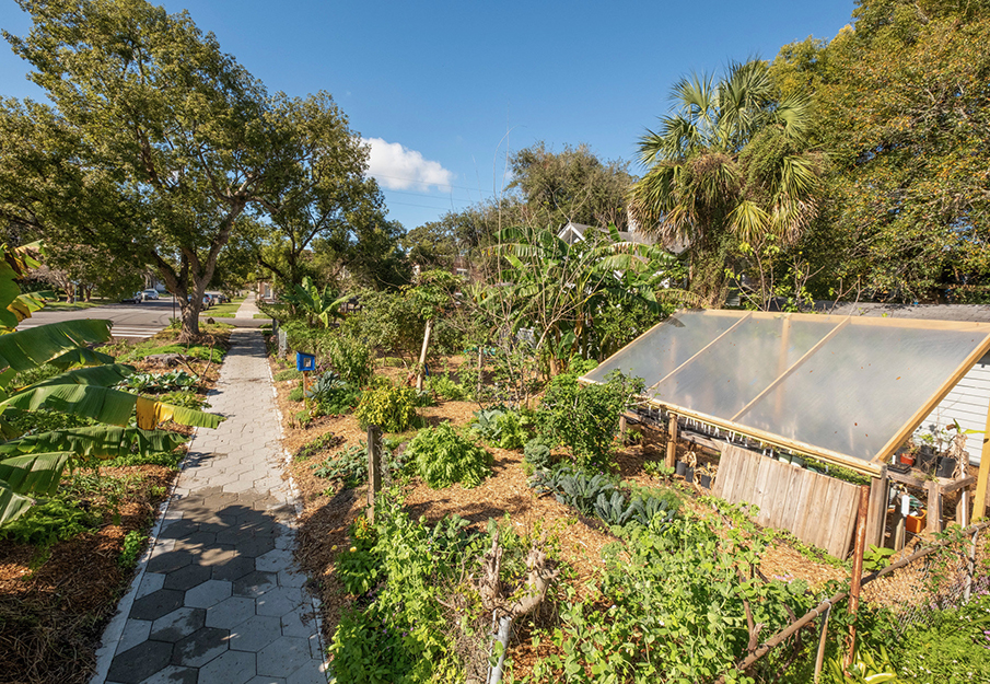 Play garden and greenhouse viewed from sidewalk.