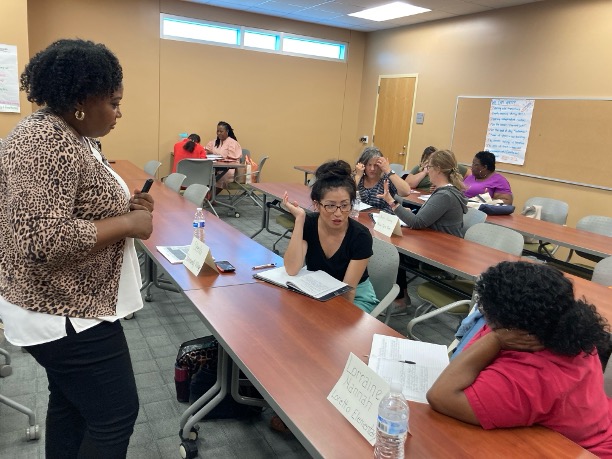 Small groups talk and write during an adult learning workshop.