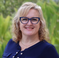 Headshot of Amy Roderick wearing blue glasses and shirt