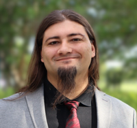 Headshot of Tyler Charles wearing suit and tie