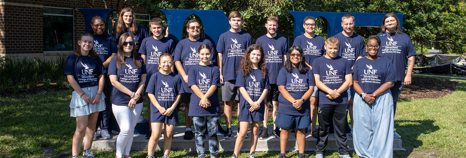 USoar group photo in front of UNF sign for 2026-27 school year