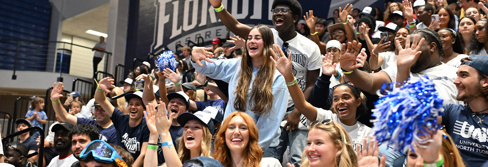 Students at a basketball game waving and cheering