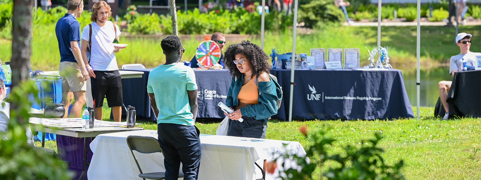 Tabling on campus lawn with students talking to various booths