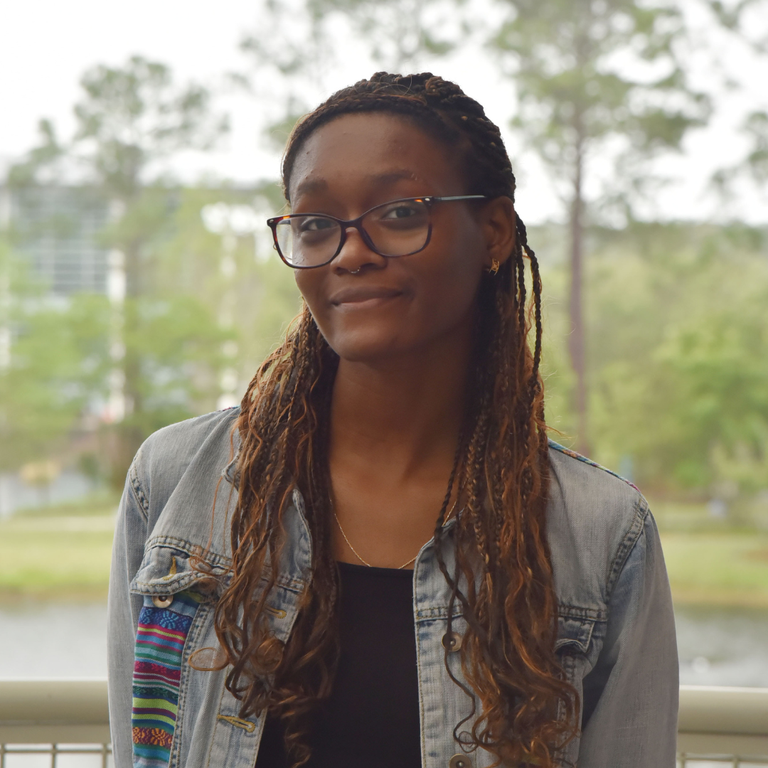 Woman wearing a denim jacket and standing outside