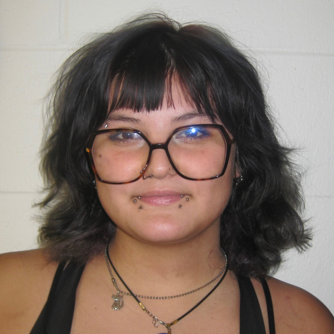 Catalina has short black hair and wears black rimmed glasses.