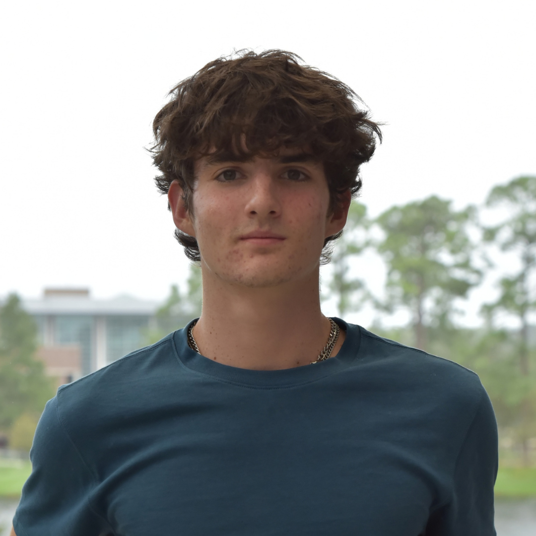 Jack has dark hair and is wearing a blue shirt