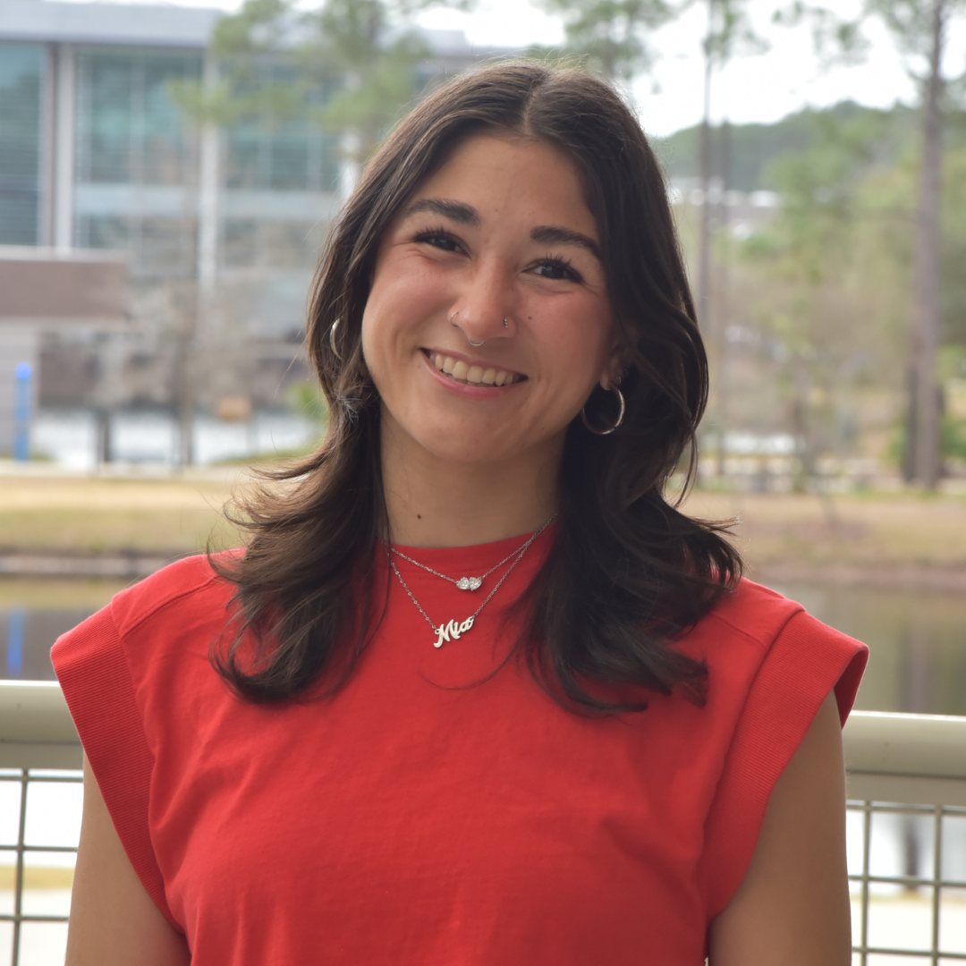 Mia is wearing a red shirt