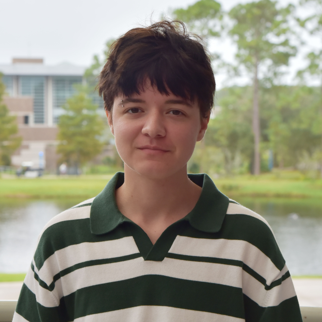 RJ standing outside with a white and green stripped shirt.