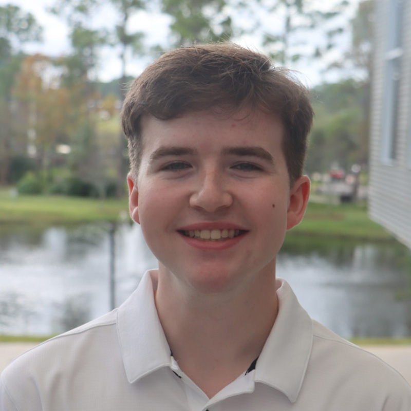 Riley in white shirt outside the student union
